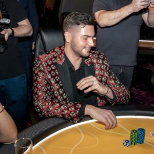 Muž v barevném saku hrající poker v kasinu Vestec