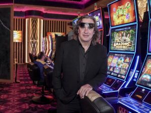 Muž v černém obleku stojící u výherních automatů v kasinu Vestec