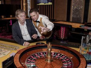 Krupiér vysvětlující pravidla muži u ruletového stolu v kasinu Vestec