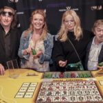 skupina-lidi-s-zetony-u-hraciho-stolu-v-kasinu-vestec-vsichni-se-usmivaji Skupina lidí s žetony u hracího stolu v kasínu Vestec, všichni se usmívají