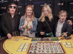 Skupina lidí s žetony u hracího stolu v kasínu Vestec, všichni se usmívají