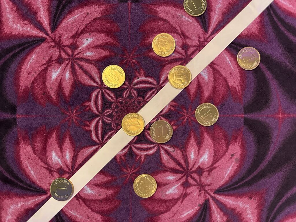 Zlaté mince na kobercu s květinovým vzorem v kasinu Vestec